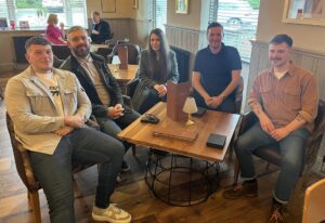 The image captures a group of five Aptus Utilities professionals at a celebratory meal, honoring the first graduates of the Aptus Academy. Featured are Multi Utility Team Leader & Water Design Engineers Liam Pearson and Lewis Higham, Street Lighting Manager Jack Farnworth, Technician Abigail Aspin, and Administration Assistant Jack Pollitt, who have all completed their qualifications. The informal setting underscores the company's commitment to celebrating the achievements of its staff and fostering a supportive culture for career progression. This photo, optimized for SEO, highlights the success of the Aptus Academy, professional development, and the nurturing of talent within the utilities industry.